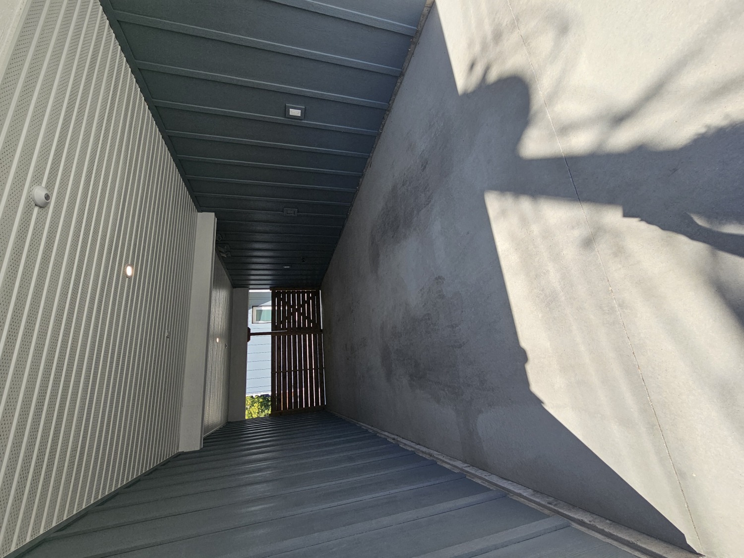 A long, narrow corridor with a shadow cast on the wall.